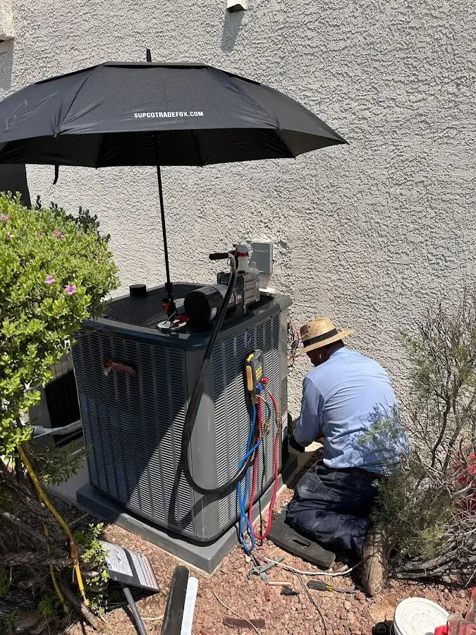 HVAC technician performing outdoor AC maintenance in Hebron