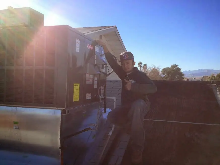 HVAC technician performing Boiler Repair on a rooftop unit in Hebron